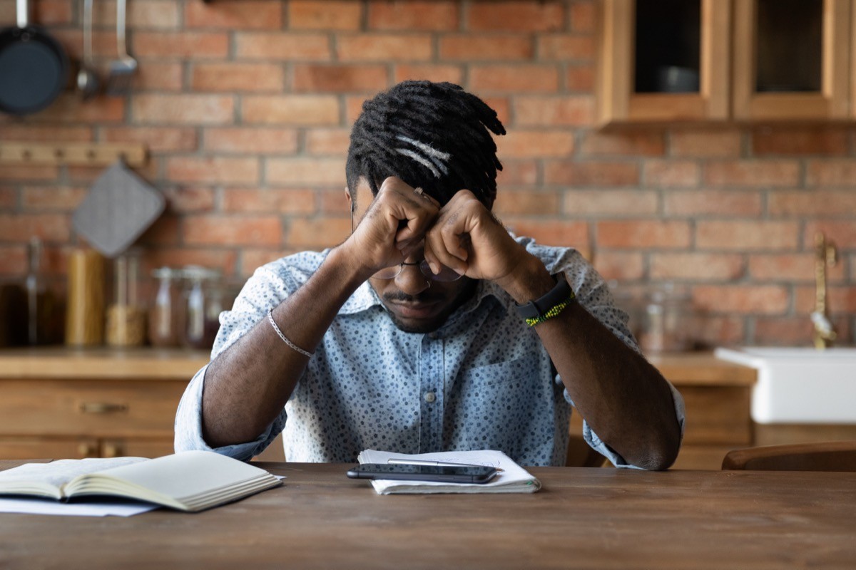 A man sitting at a table looking very tired
