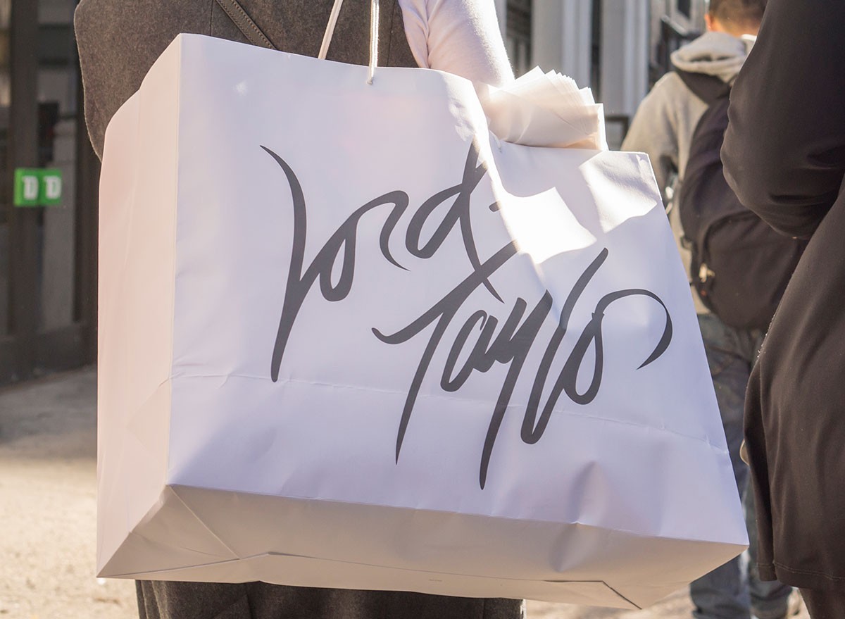 A woman carrying a Lord & Taylor shopping bag