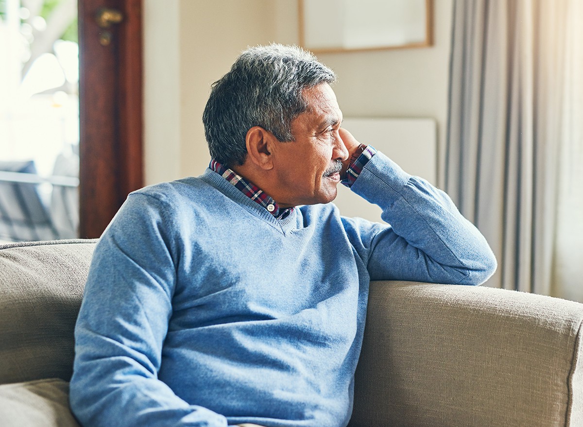 A senior man looks out the window