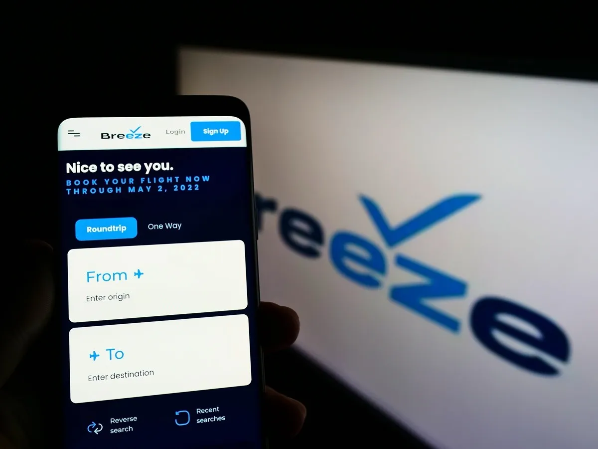 booking a flight on a mobile phone with breeze airways