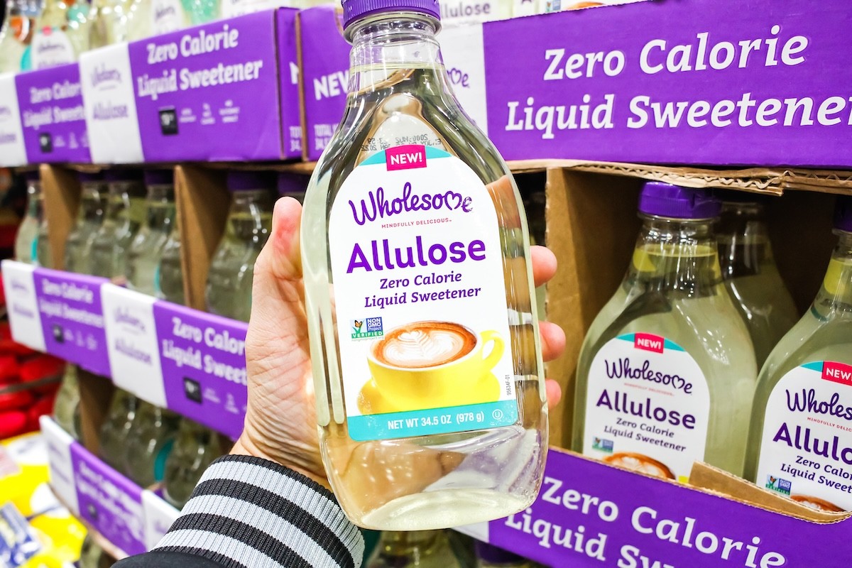 person holding up a bottle of allulose liquid sweetener at the grocery store