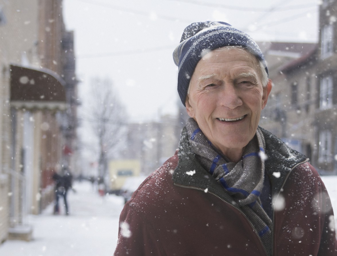 closeup of a smiling senior man outside on a snowy day