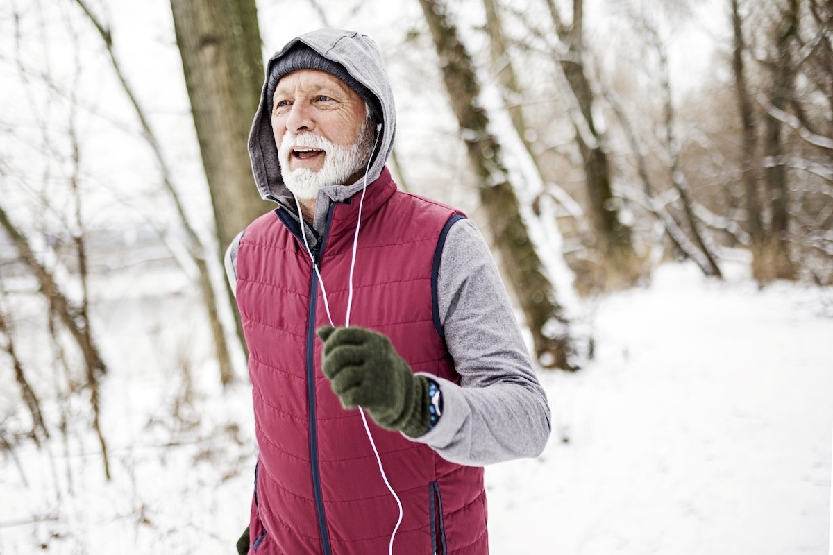 mature man jogging in the snow
