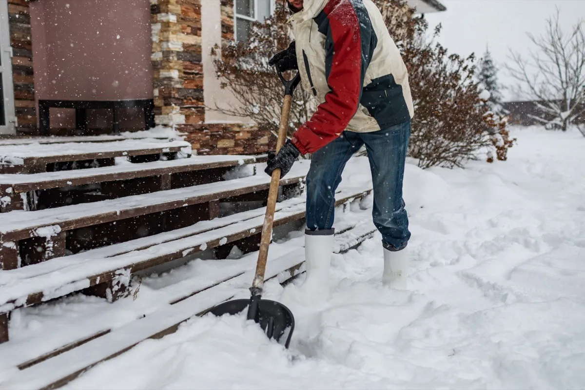 man shoveling snow from front steps
