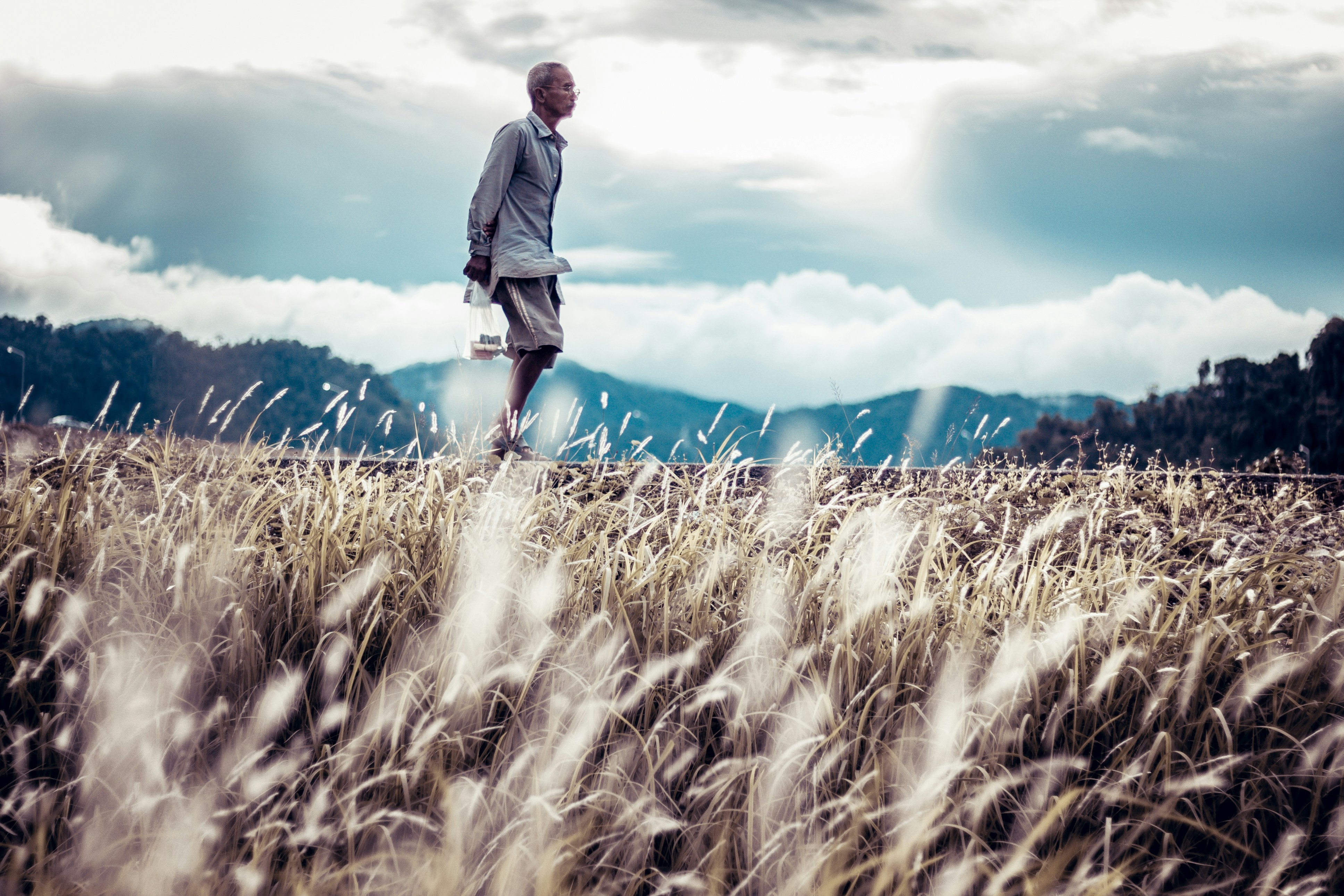 man relaxes while going for a walk in an open field