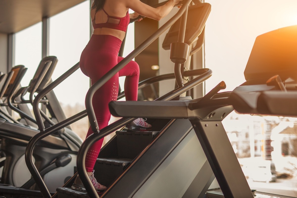 woman in red workout gear on the stairmaster at the gym