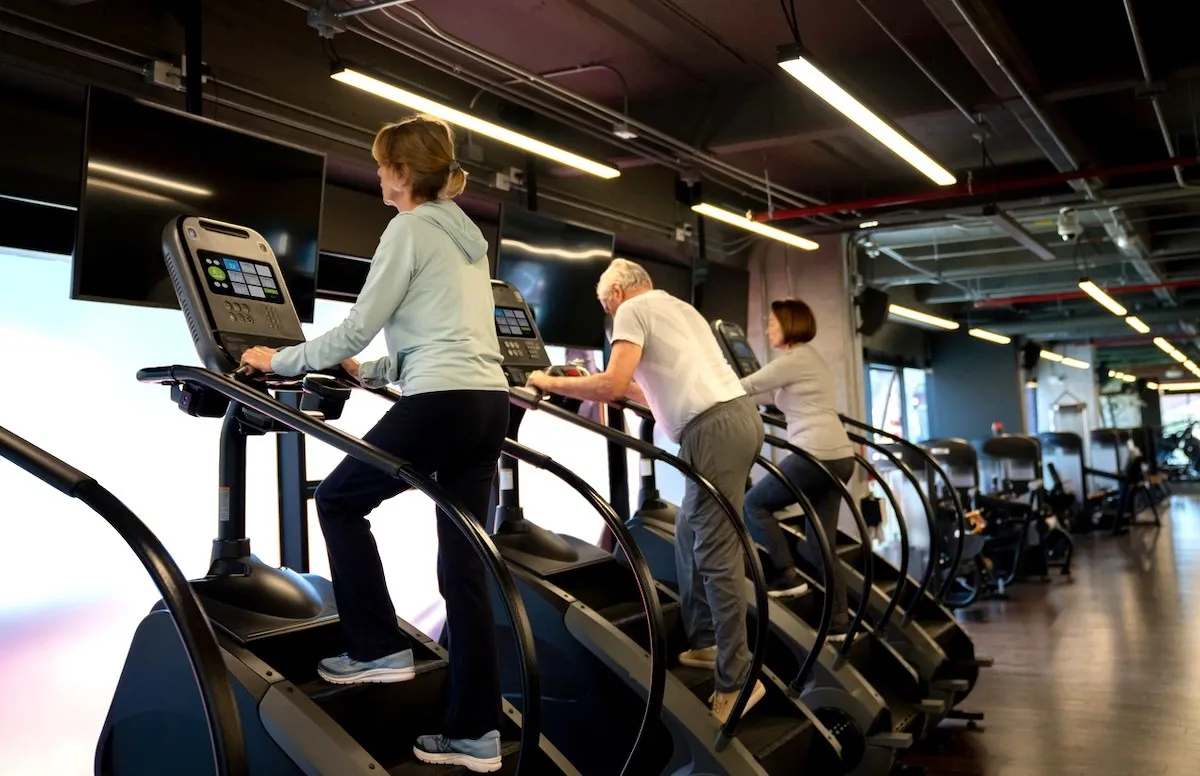 mature adults on stairmaster machines at the gym