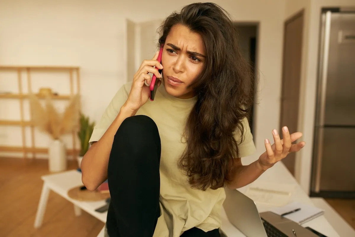 frustrated young woman talking on her cell phone