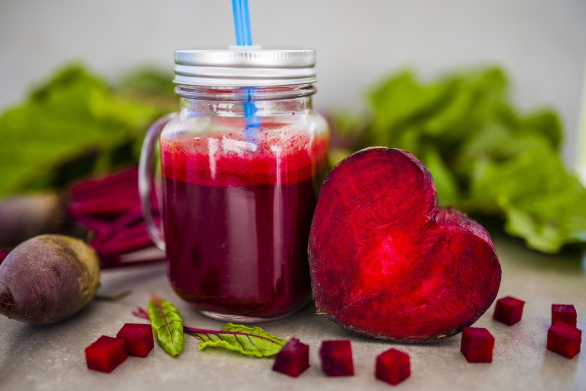 Beet juice in a mason jar next to heart shaped beet