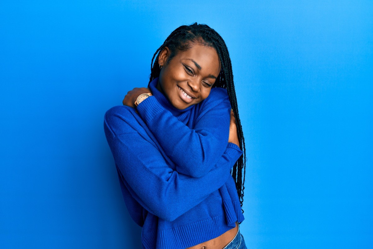 Young woman in a blue sweater against a blue background