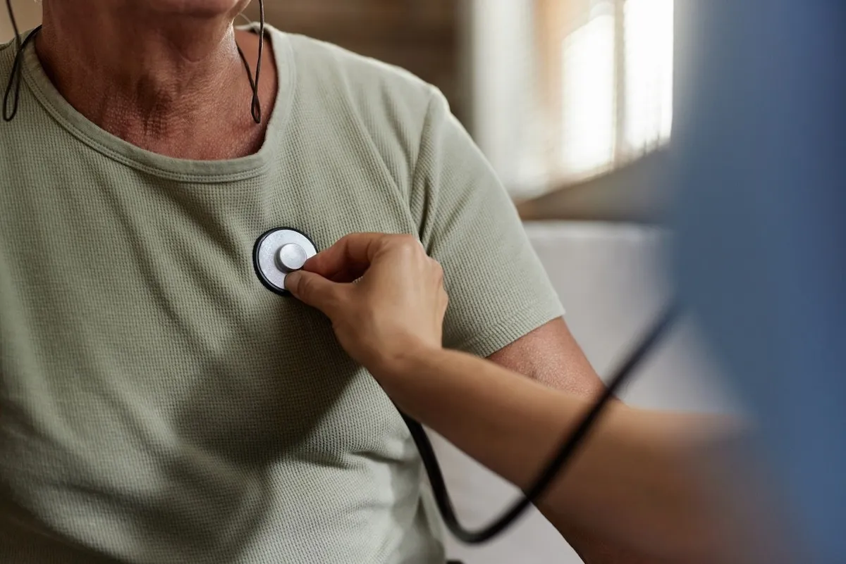 closeup of a doctor listening to a patient's heartbeat