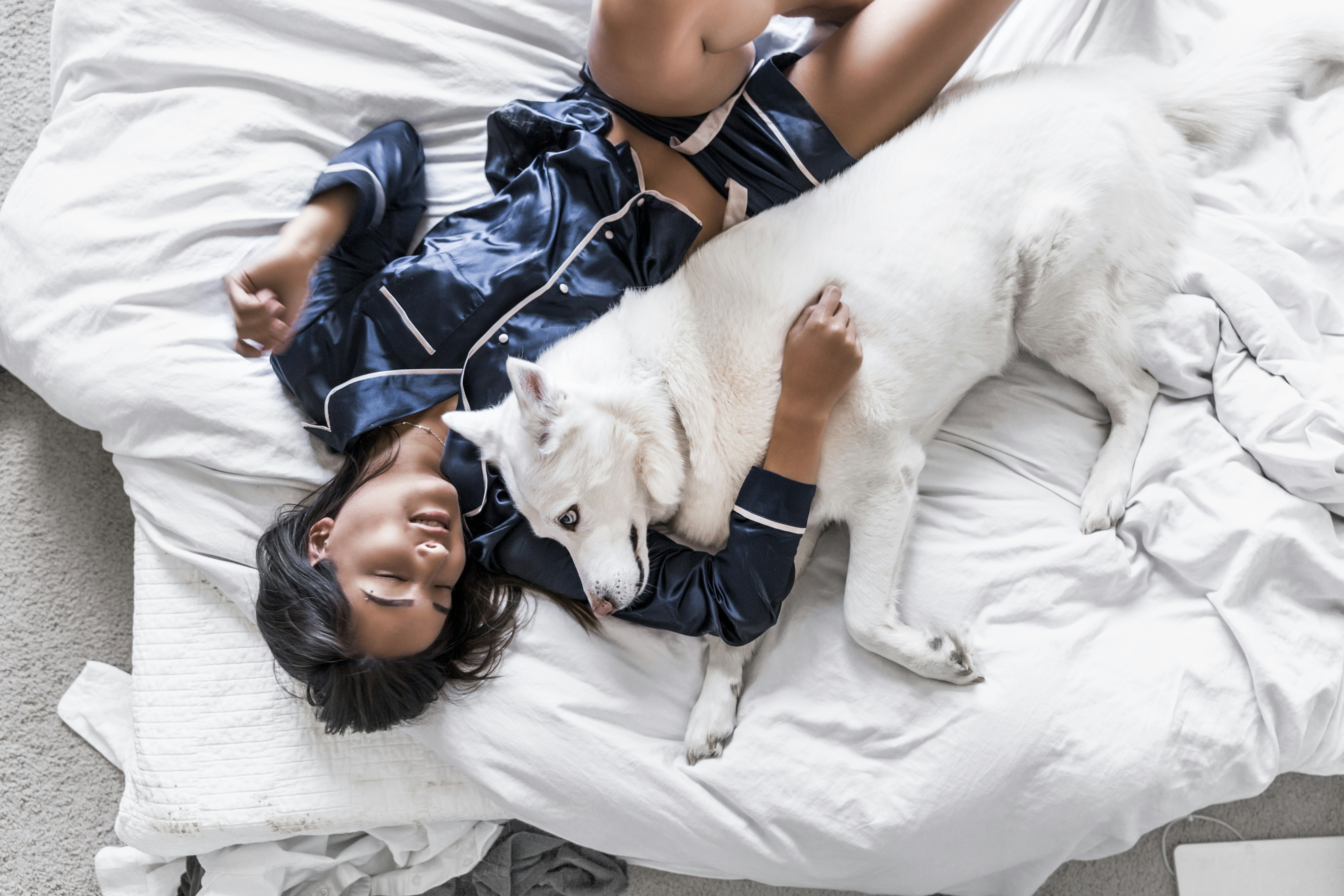 a woman sleeps with a dog