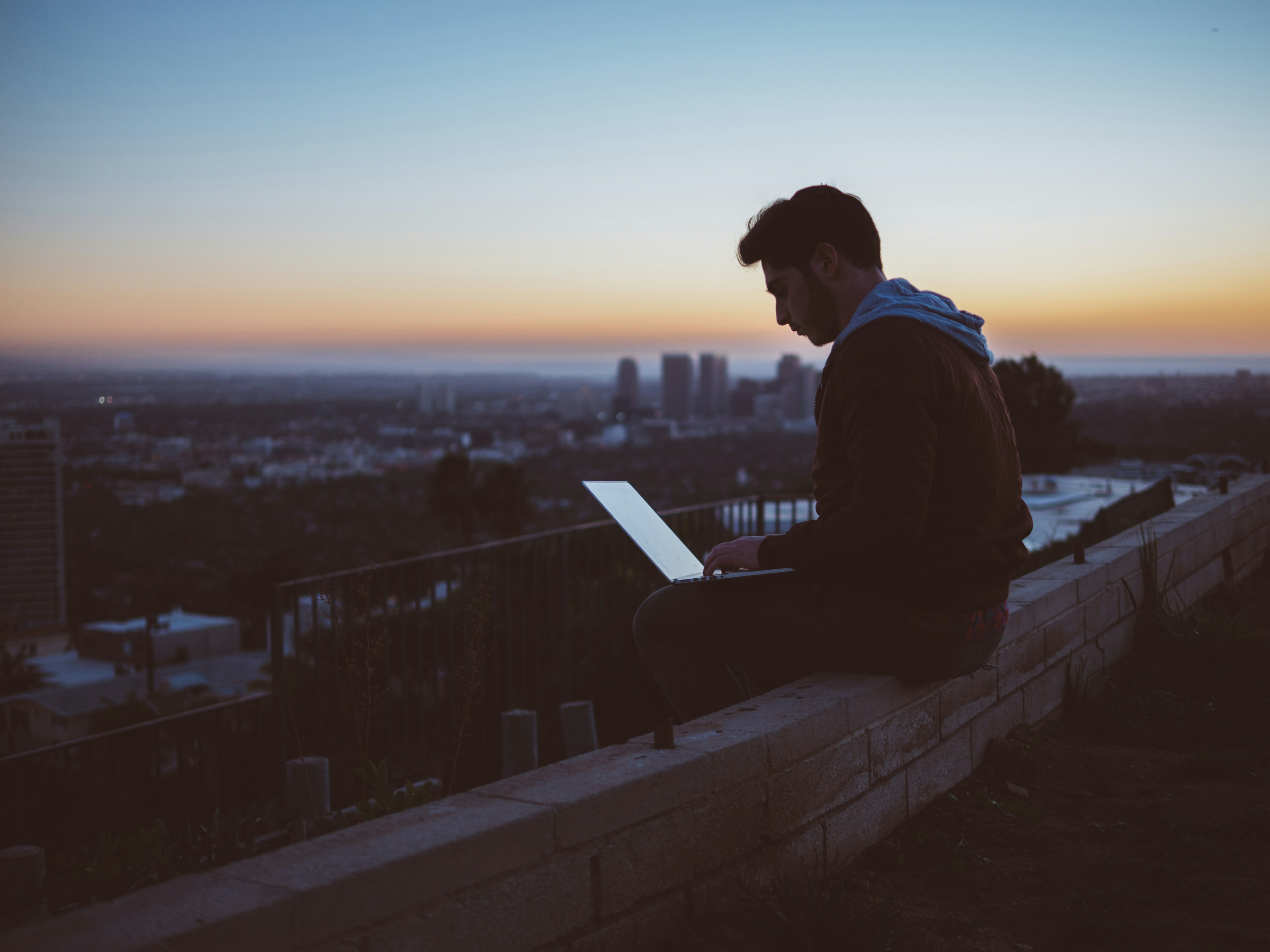 a man works on his laptop outdoors