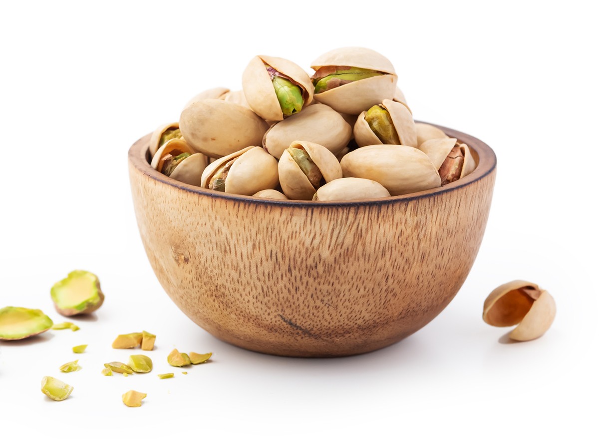 A bowl of pistachios on a white background