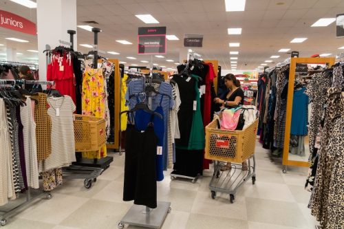 woman shopping with cart in clothing section of T.J. Maxx