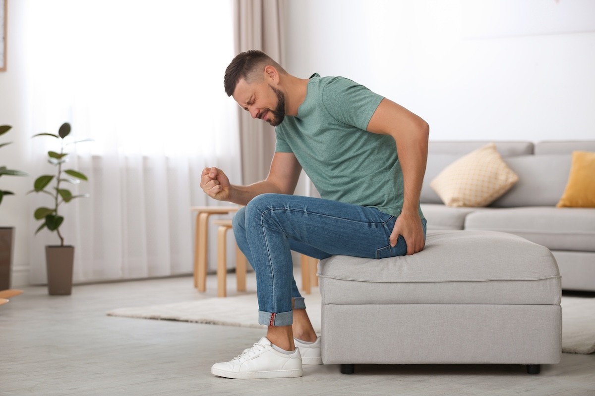 man with butt pain while sitting