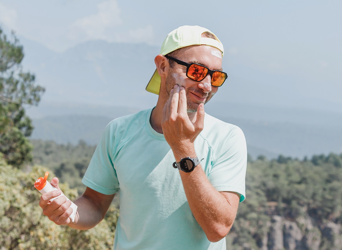 Man applying sunscreen to his face