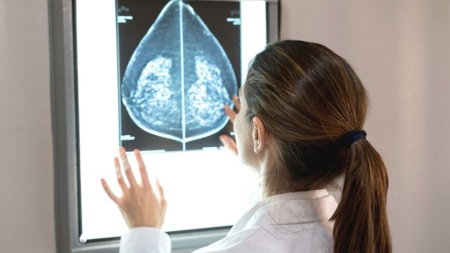 rear view of a woman looking at a breast MRI scan