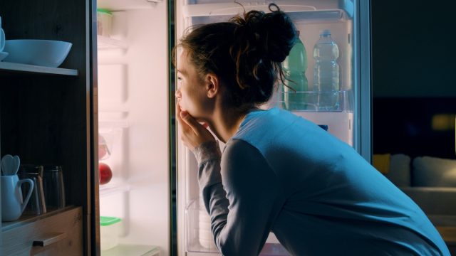 woman looking in fridge at night