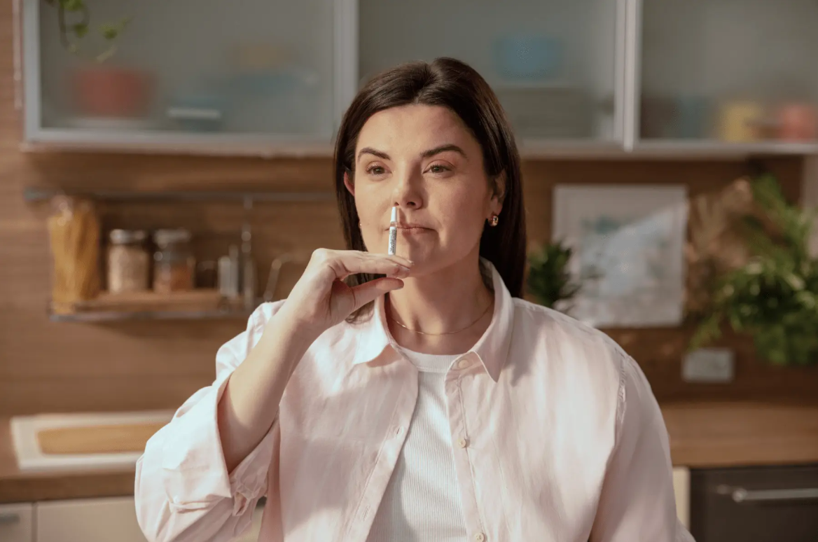 Woman using a FluMist vaccine at home