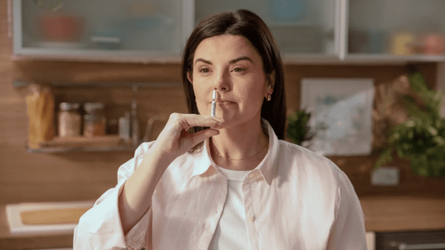 Woman using a FluMist vaccine at home