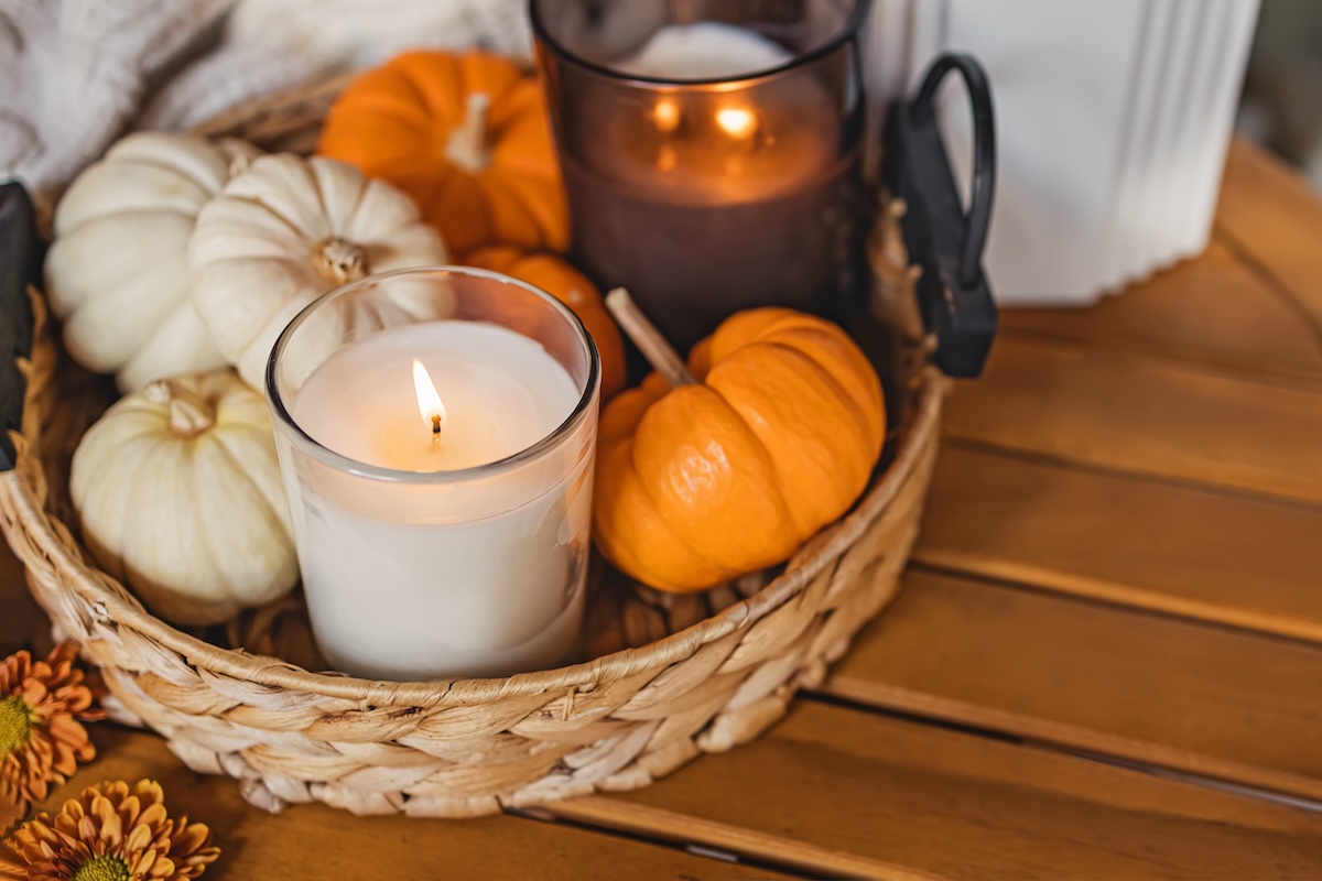 candles and mini pumpkins in a round basket