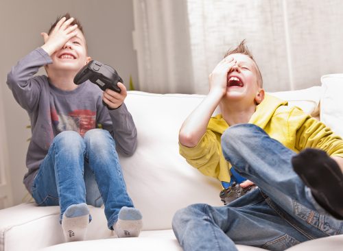 two little boys having lots of fun with video games