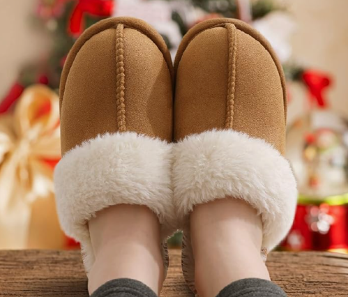camel-colored shearling slippers on a pair of feet