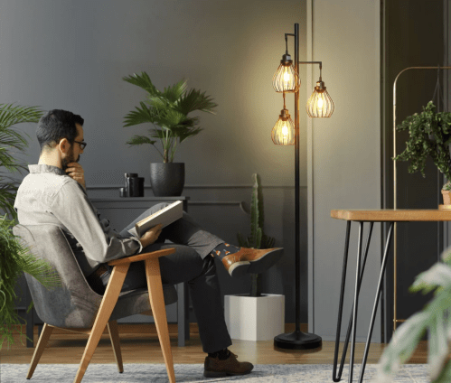 man in living room in a chair next to a standing lamp