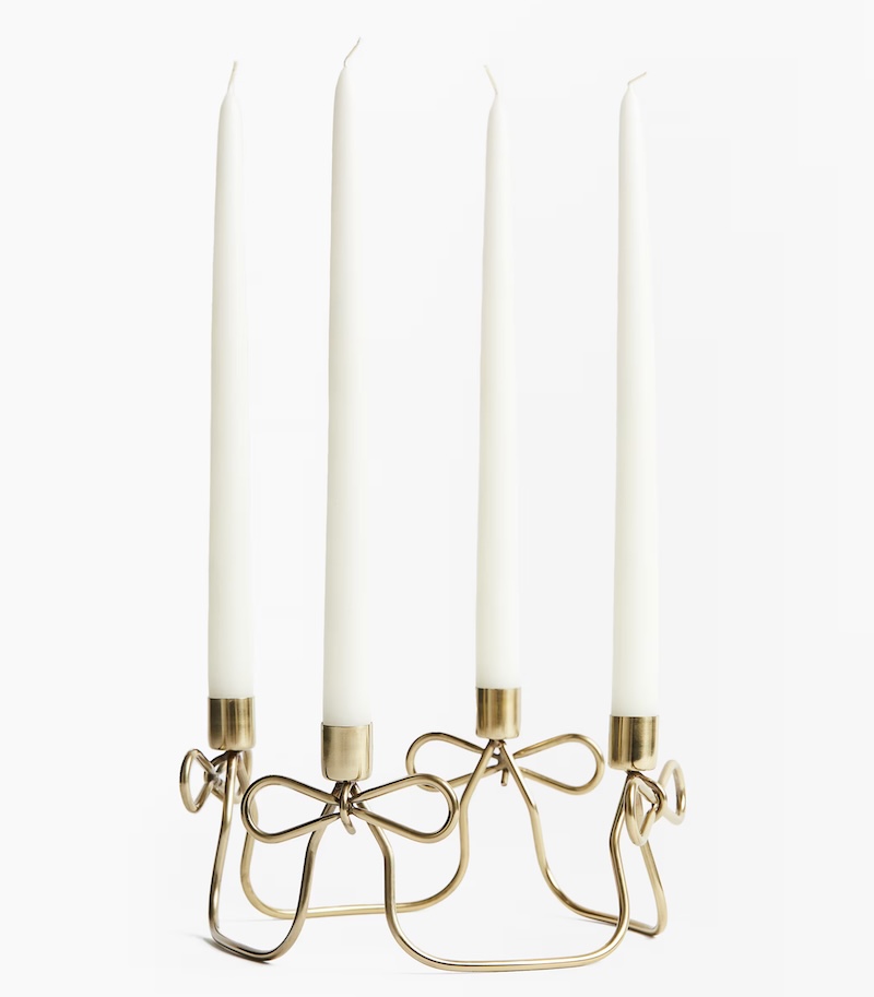 A golden metal candelabra with candles inserted in it