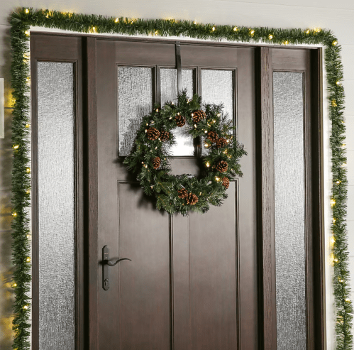 front door with a Christmas wreath and garland