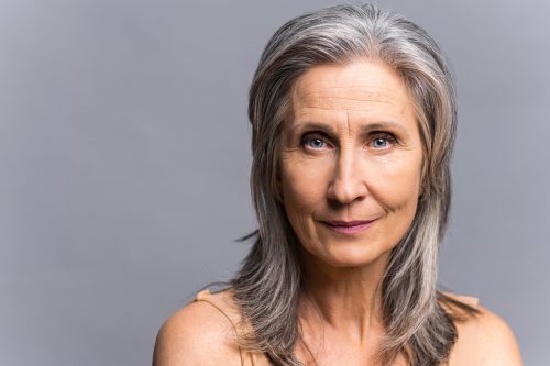 closeup of a mature woman with layered gray hair