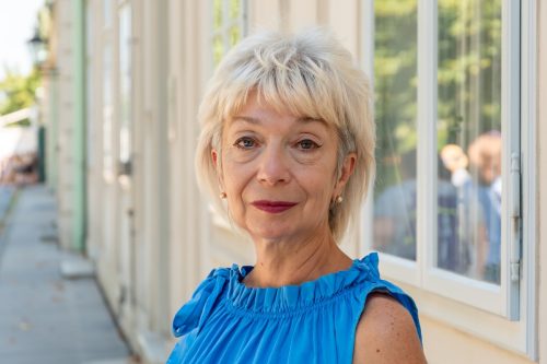 closeup of a mature woman in a blue top with short teased hair