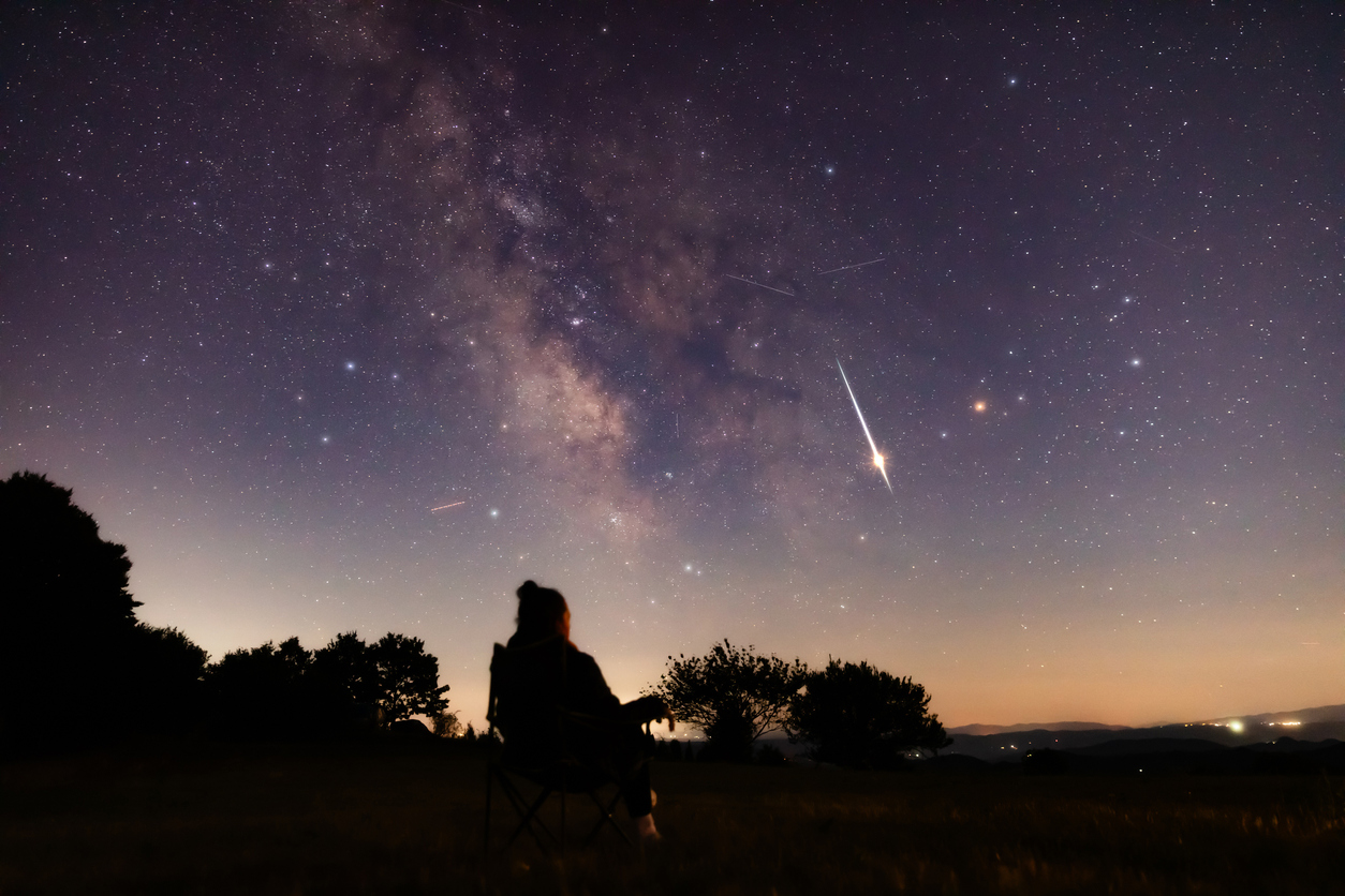 The silhouette of a person looking up at the night sky