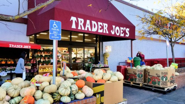 trader joe's store with a display of pumpkins outside
