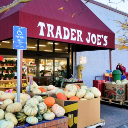 trader joe's store with a display of pumpkins outside