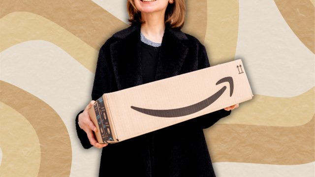 woman in a black sweater holding an amazon box against a beige swirly background