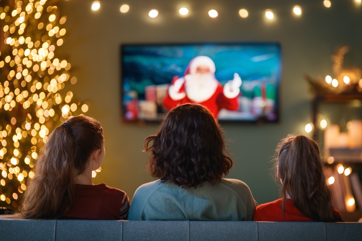 rear view of three women on the couch watching a Christmas movie