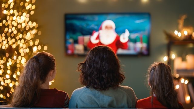 rear view of three women on the couch watching a Christmas movie