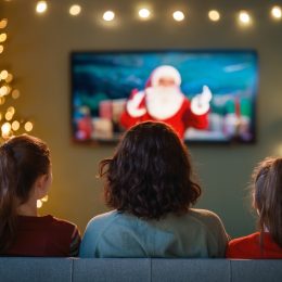 rear view of three women on the couch watching a Christmas movie