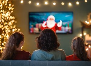rear view of three women on the couch watching a Christmas movie