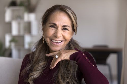 portrait of a smiling mature woman wearing a burgundy sweater