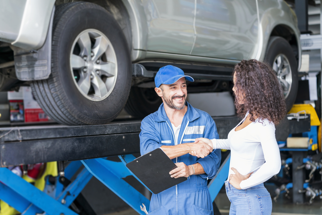 A mechanic shaking hands with a female customer
