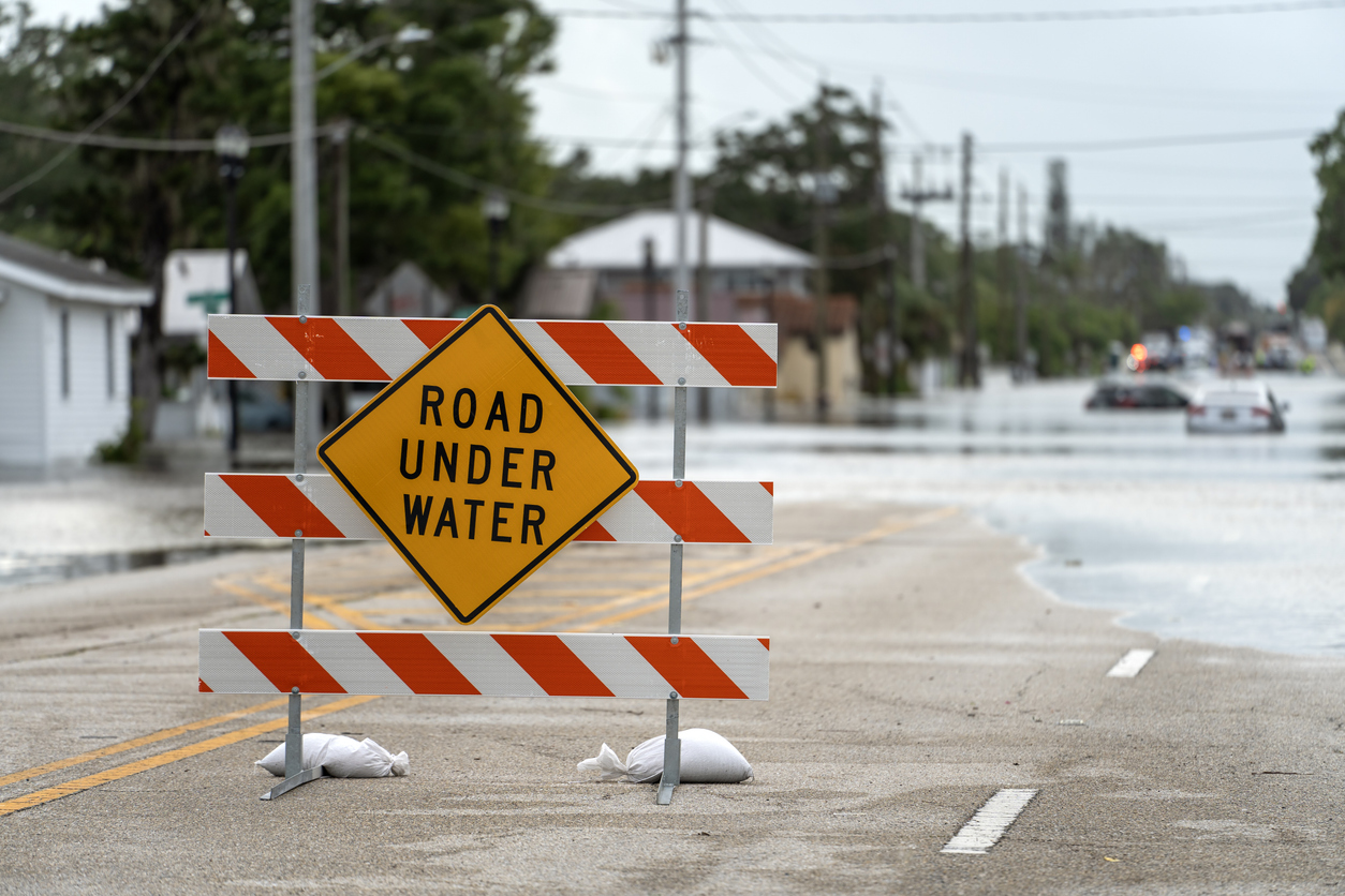A Road Under Water sign on a flooded street