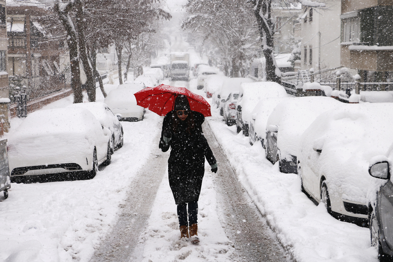 A young woman walking through the snow in a city