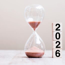 2026 text with hourglass on table.
