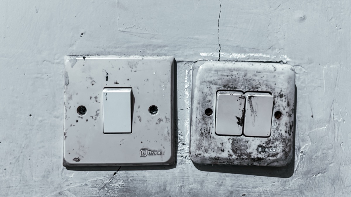 Old and Dirty Light Switches on a Worn Wall