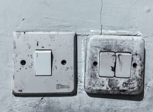 Old and Dirty Light Switches on a Worn Wall