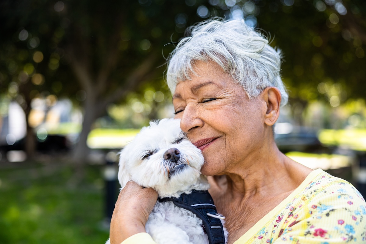 mature woman hugging her dog outside