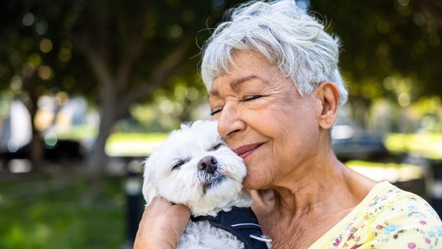mature woman hugging her dog outside